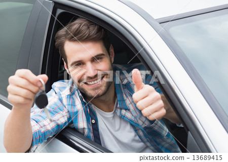 Young man smiling and holding key Young man smiling and holding key 13689415