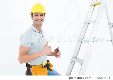 Technician with tools showing thumbs up by step ladder Technician with tools showing thumbs up by step ladder 13689691