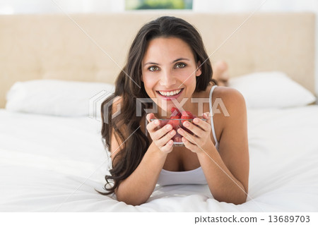 Happy brunette with bowl of strawberries Happy brunette with bowl of strawberries 13689703