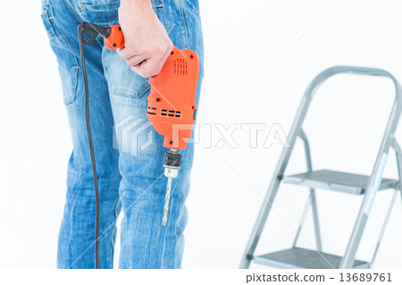 Worker holding drill in front of step ladder Worker holding drill in front of step ladder 13689761