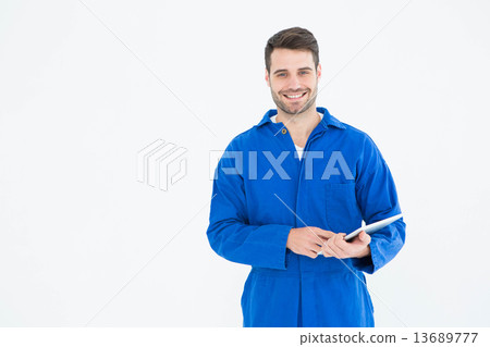 Happy young male mechanic using digital tablet Happy young male mechanic using digital tablet 13689777