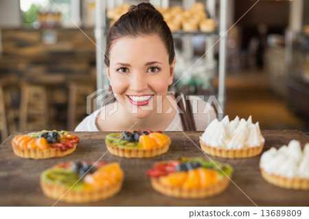 Pretty brunette looking at tarts Pretty brunette looking at tarts 13689809