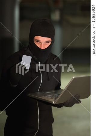 Hacker using laptop to steal identity Hacker using laptop to steal identity 13689924