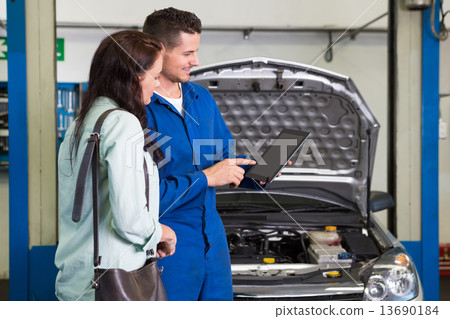 Mechanic showing customer the problem with car Mechanic showing customer the problem with car 13690184