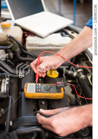 Mechanic using diagnostic tool on engine Mechanic using diagnostic tool on engine 13690336