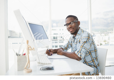 Smiling casual businessman writing on paper 13690460