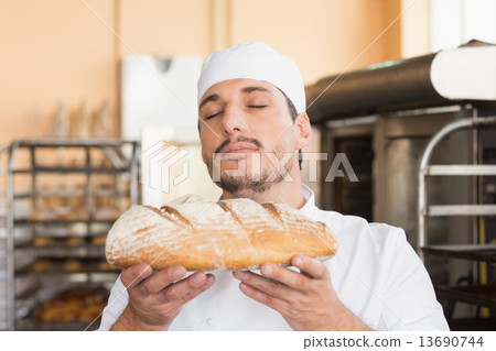 Baker smelling freshly baked loaf Baker smelling freshly baked loaf 13690744