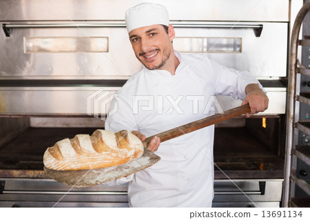 Happy baker taking out fresh loaf Happy baker taking out fresh loaf 13691134
