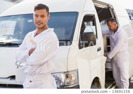 Painter smiling leaning against his van 13691158
