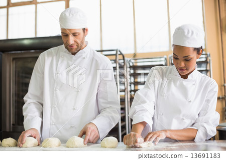 Team of bakers preparing dough Team of bakers preparing dough 13691183