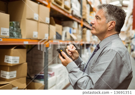Focused male manager using handheld 13691351