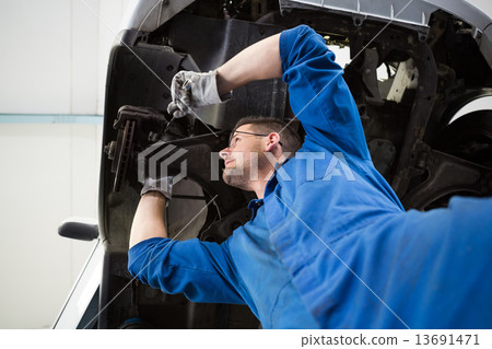 Focused mechanic adjusting the wheel 13691471