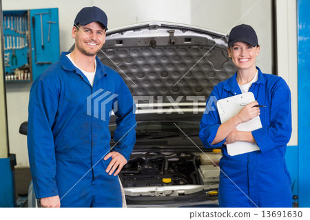 Team of mechanics smiling at camera Team of mechanics smiling at camera 13691630