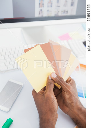 Designer holding colour swatch and choosing Designer holding colour swatch and choosing 13691863