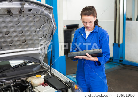 Mechanic examining under hood of car Mechanic examining under hood of car 13691996