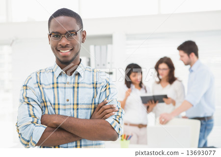 Smiling businessman with arms crossed 13693077