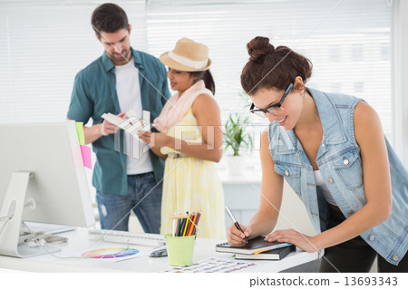 Colleagues using colour wheel behind a smiling woman Colleagues using colour wheel behind a smiling woman 13693343