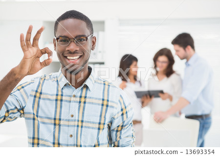 Positive businessman making okay gesture Positive businessman making okay gesture 13693354