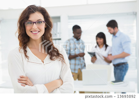 Smiling businesswoman with arms crossed Smiling businesswoman with arms crossed 13693892