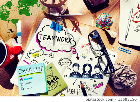 Desk with Tools and a Notebook with Ideas About Teamwork 13695150