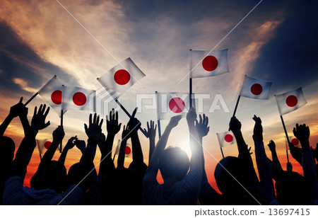Silhouettes of People Holding the Flag of Japan 13697415