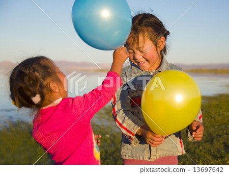 Two Little Girls Playing With Each Other With Balloons Two Little Girls Playing With Each Other With Balloons 13697642