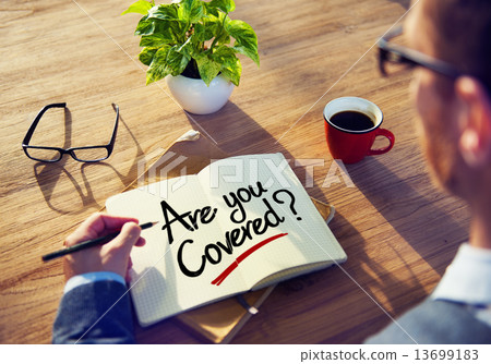 Businessman Writing the Words "Are you Covered?" Businessman Writing the Words "Are you Covered?" 13699183
