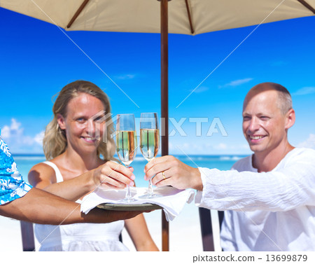 Woman and Man Having Champagne by the Beach 13699879