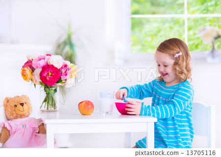 Little girl eating breakfast Little girl eating breakfast 13705116