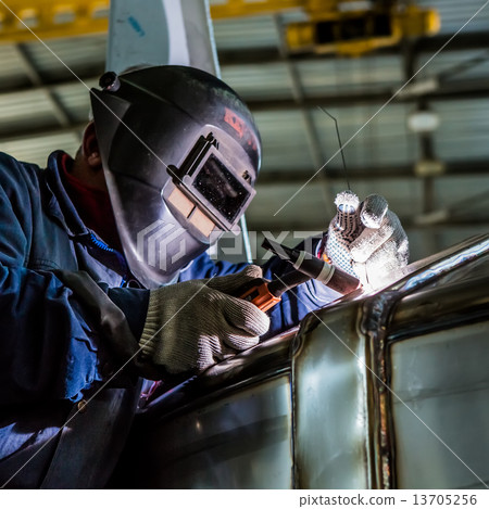 Man welding with reflection of sparks on visor. Hard job. Man welding with reflection of sparks on visor. Hard job. 13705256