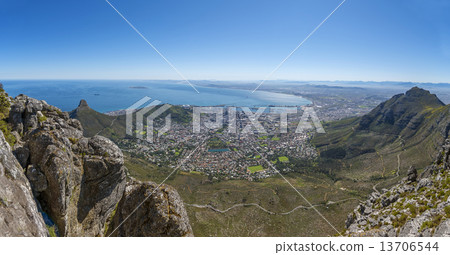 View from the flat top of Cape Town's Table Mountain. Views of Cape Town city, Atlantic ocean, harbor and Lion's Head hiking peak can be seen from the various cliff orientated mountain outlooks. 13706544