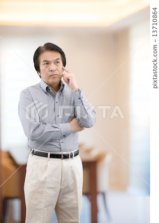 Middle-aged man in casual wear standing at home living 13710864