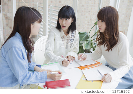 Female students sitting in a chair and showing notes Female students sitting in a chair and showing notes 13716102