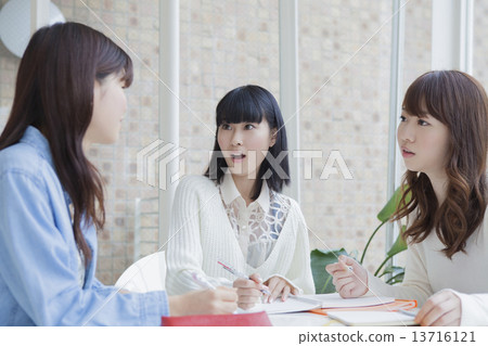 Female students sitting in a chair and showing notes 13716121