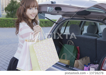 A woman surprised to open the trunk of a car 13716278
