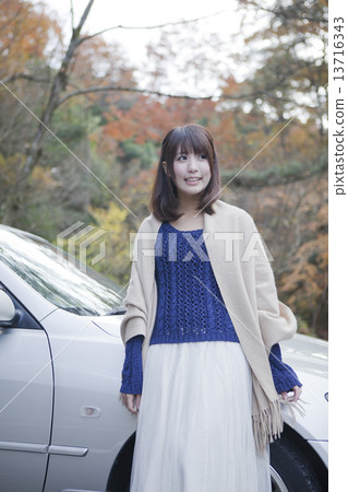 站立在汽車前面的婦女在停車場在秋葉公園 13716343