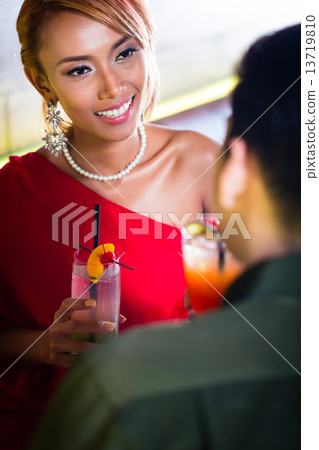 Asian couple drinking cocktails in fancy bar 13719810