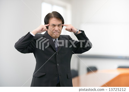 一個穿著西裝站在公司會議室裡的中年男子 13725212