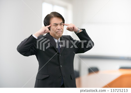 一個穿著西裝站在公司會議室裡的中年男子 13725213