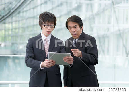 穿著在一個現代大廈的衣服的兩個人一種片劑 13725233