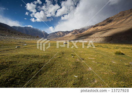 field against the background of distant colorful mountain range 13727928