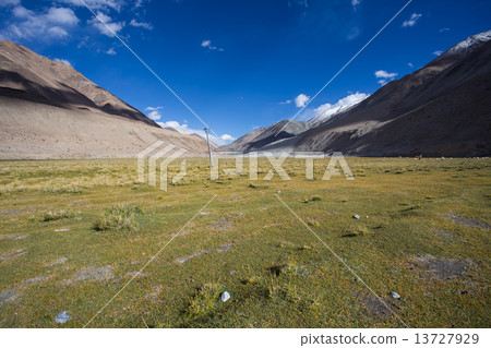 field against the background of distant colorful mountain range 13727929