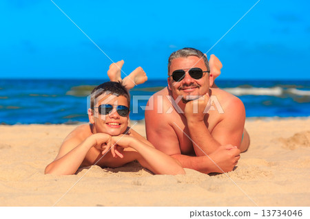 Happy young boy and man on the sea beach 13734046