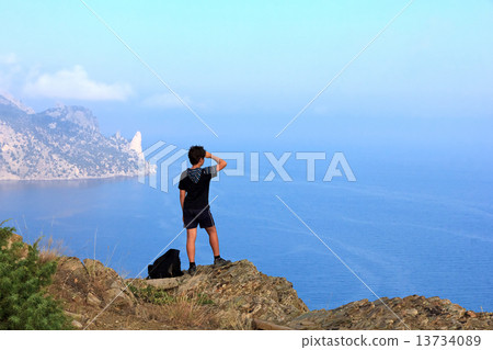 Young traveler looks at the beautiful seascape from the mountain Young traveler looks at the beautiful seascape from the mountain 13734089