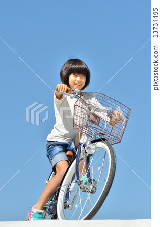 A girl riding a bicycle 13734495