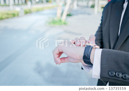 Businessman checking the time Businessman checking the time 13735559