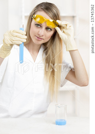 young woman doing experiment in laboratory young woman doing experiment in laboratory 13745362