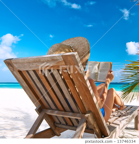 Young woman reading a book at beach 13746334