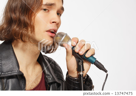 Young handsome rock singer holding microphone Young handsome rock singer holding microphone 13747475