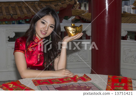 Girl holding Yuanbao with an assortment of CNY items Girl holding Yuanbao with an assortment of CNY items 13751421